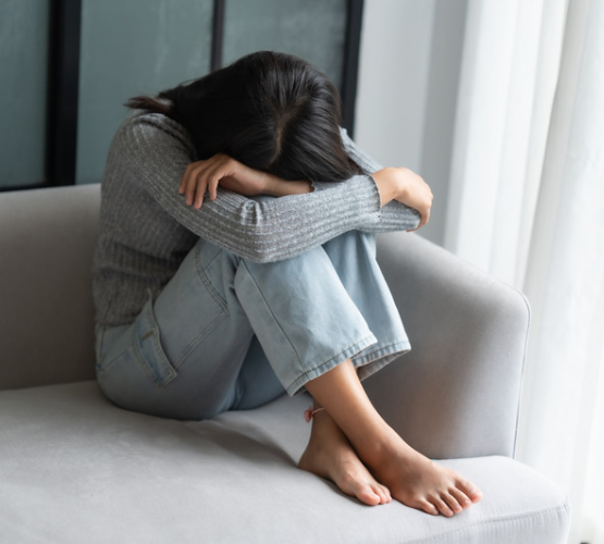 季節の変わり目に寒暖差や気圧の変化で頭痛や体の不調・だるさを感じている女性