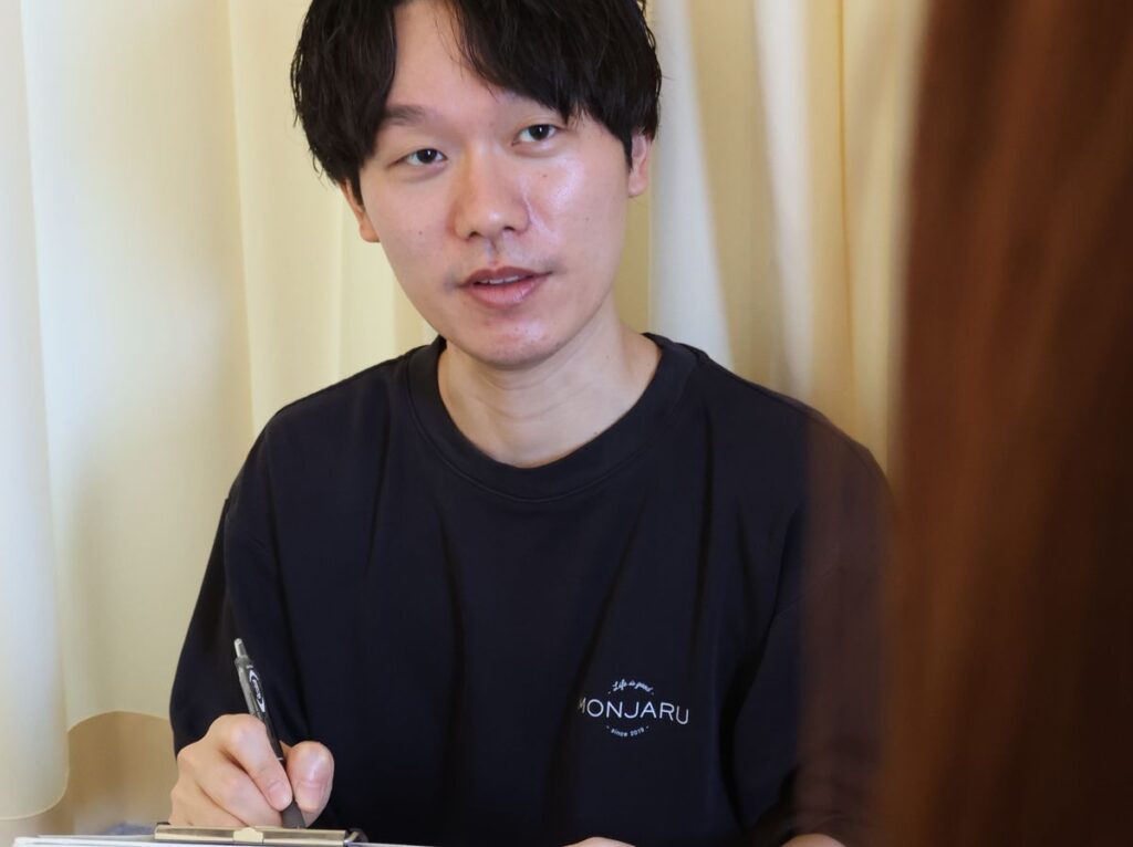 倉敷の鍼灸院もんじゃるのスタッフ八杉が問診をしている写真。