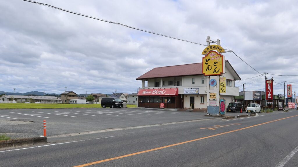 博多ラーメンとんとんと共有の駐車場と、もんじゃる倉敷下庄店の建物